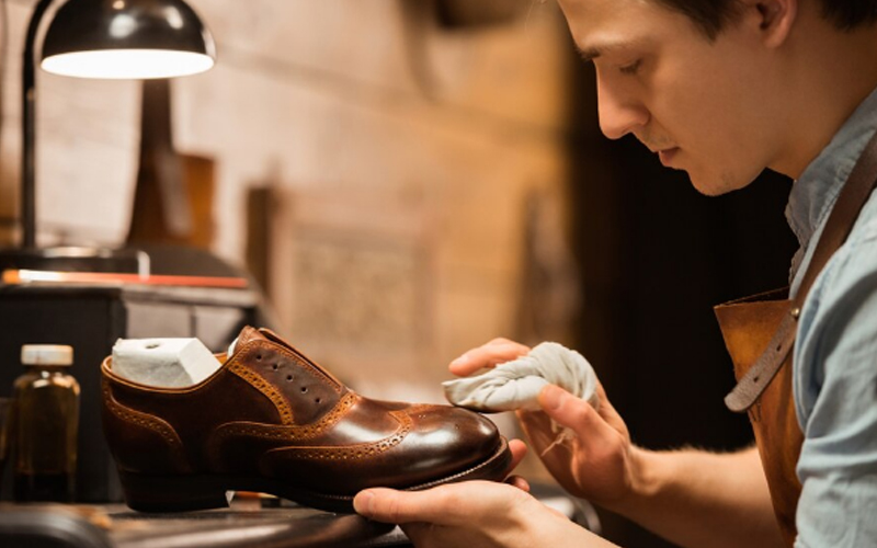 a shoemaker cleaning the shoe